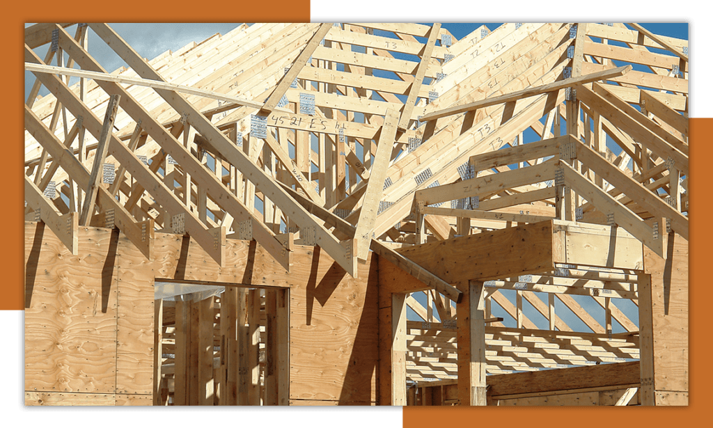 Image of a new home construction framing with roof trusses added.